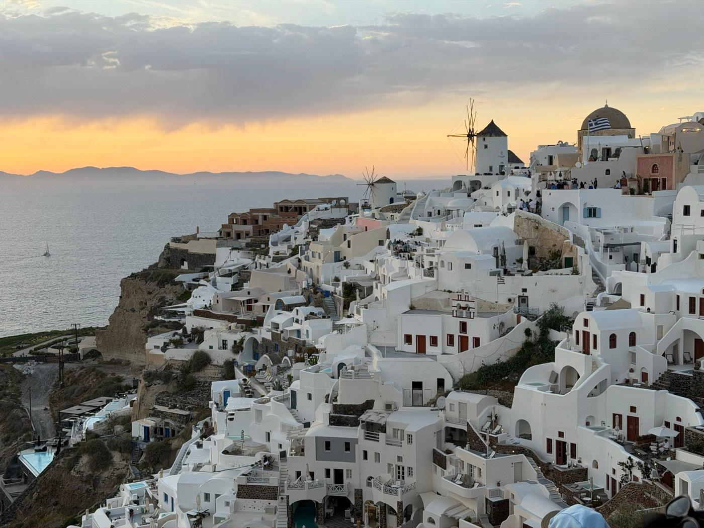 Sunset over the windmills and white buildings of Oia